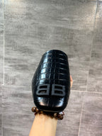 Black croc-embossed slide sandal with BB logo front, held up