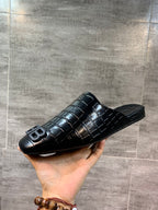 Black croc-embossed slide sandal with BB logo, angled in hand