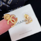Chanel earrings close-up: gold-tone CC shell studs with rhinestone details