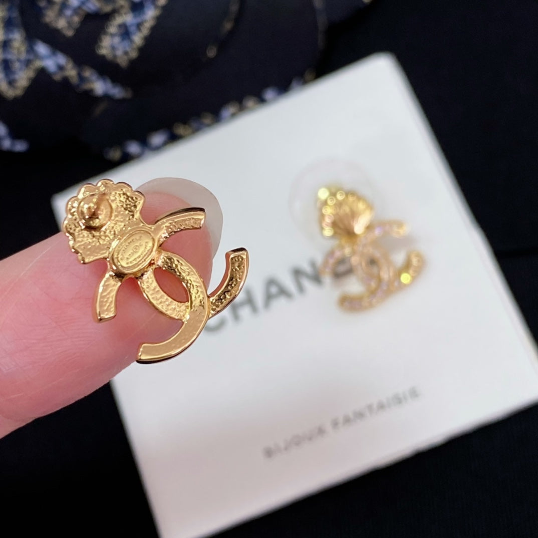 Chanel earrings close-up: gold-tone CC shell stud with rhinestone details