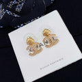 Chanel stud earrings with gold-tone shell and CC logo, rhinestone accents