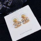 Chanel stud earrings with gold-tone shell and CC logo, rhinestone accents