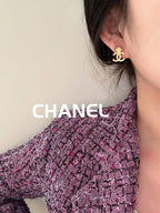 Chanel stud earrings with gold-tone CC shell motif worn on ear