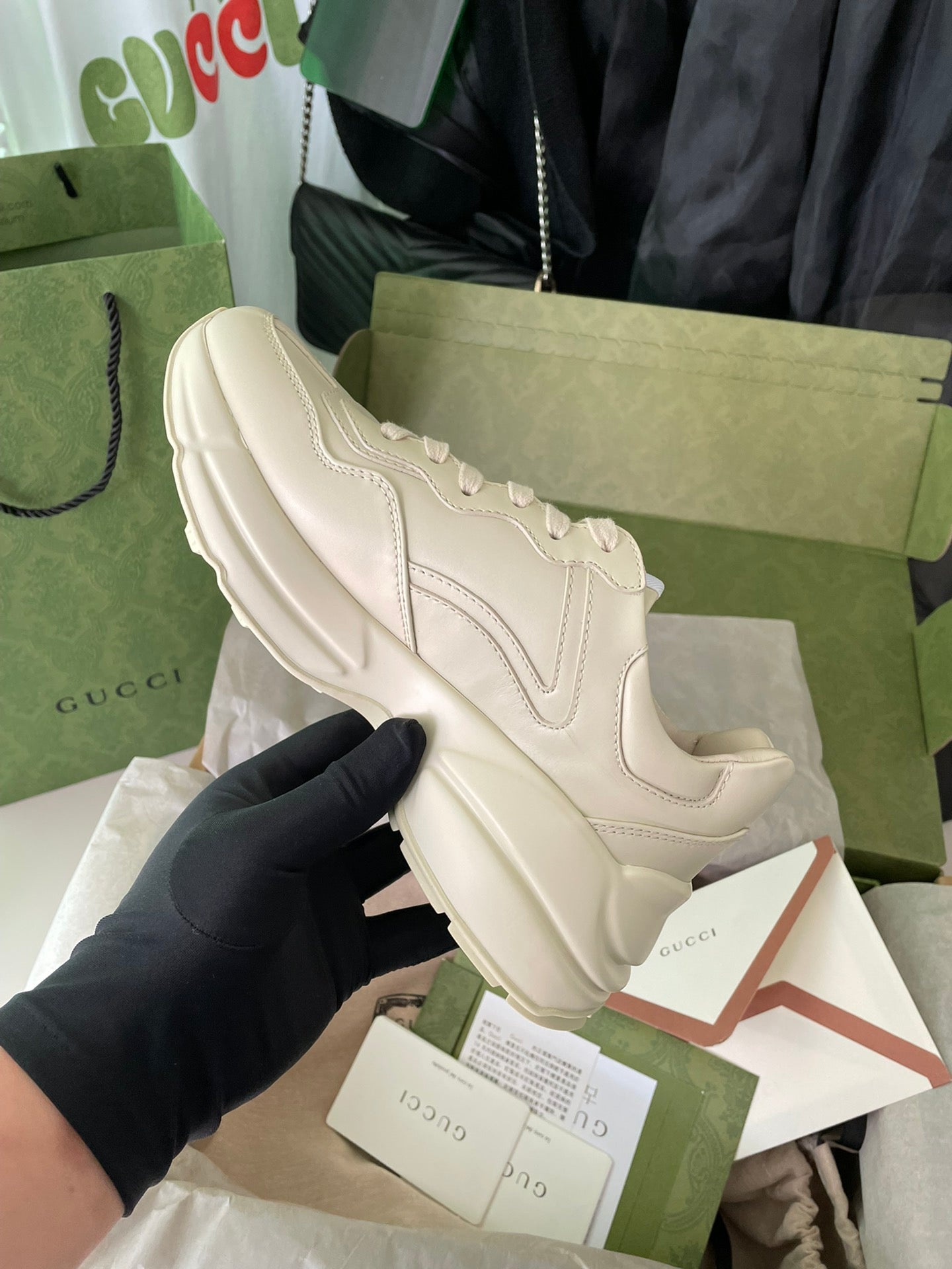 Cream Gucci lace-up sneakers with stitched panels and chunky sole.