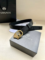 Black leather belt with textured strap and gold-tone crest buckle on box display