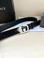 Black leather belt with textured strap and silver-tone crest buckle, laid flat