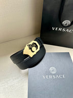 Black textured leather belt with gold-tone Medusa logo buckle and pin holes.