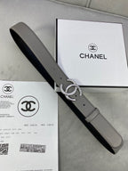 Two-tone leather belt with silver-tone double C buckle on gray strap, adjustable pin holes