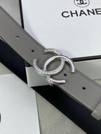 Gray leather belt with silver-tone double C buckle with rhinestones, side view detail