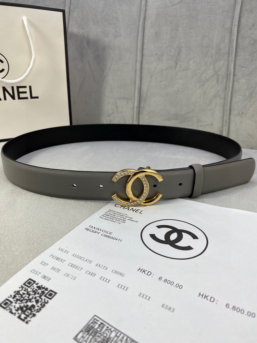 Two-tone leather belt with gold-tone double C buckle and small stud holes, dark gray finish