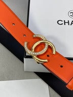 Close-up: orange leather belt with gold-tone CC buckle and rhinestone trim