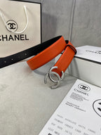 Orange leather belt with silver rhinestone CC buckle and visible sizing holes
