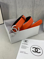 Orange leather belt with silver rhinestone CC buckle, resting in open box