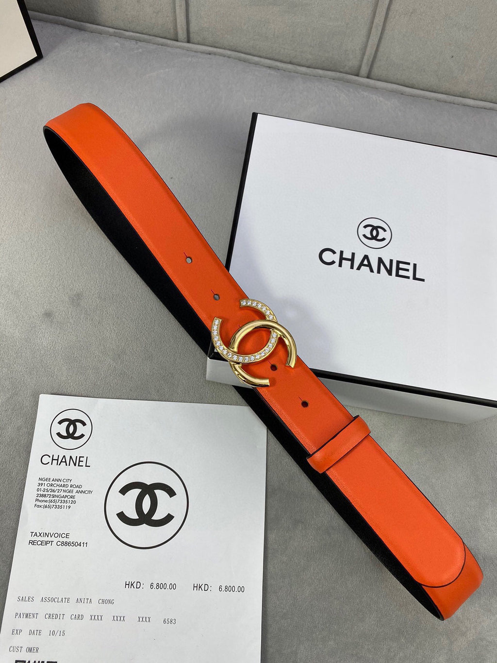 Orange leather belt with black underside and silver rhinestone CC buckle