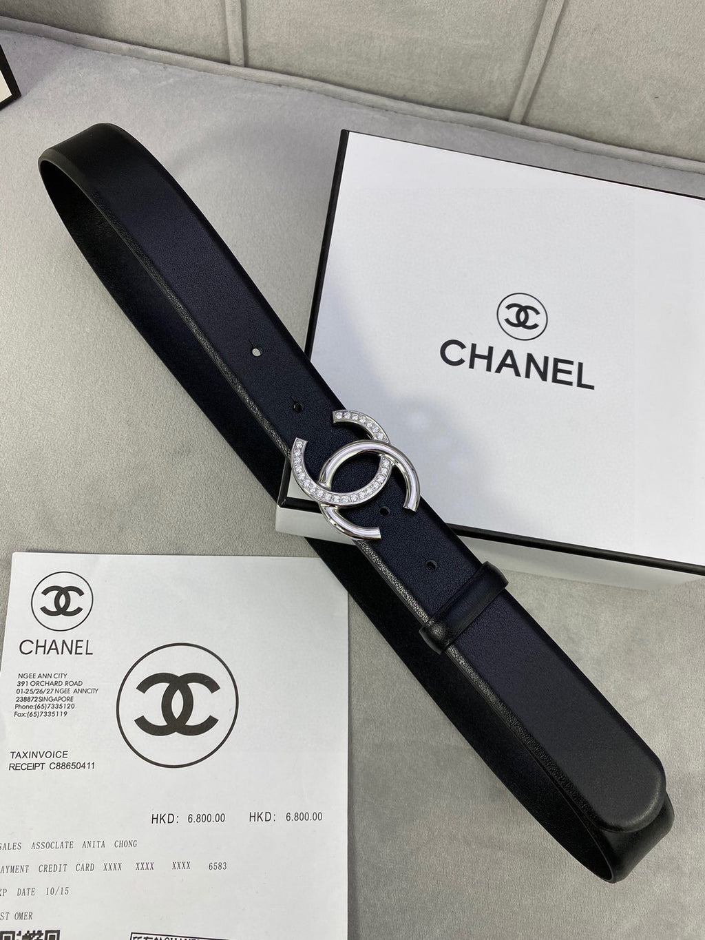 Black leather belt with silver-tone CC buckle on packaging