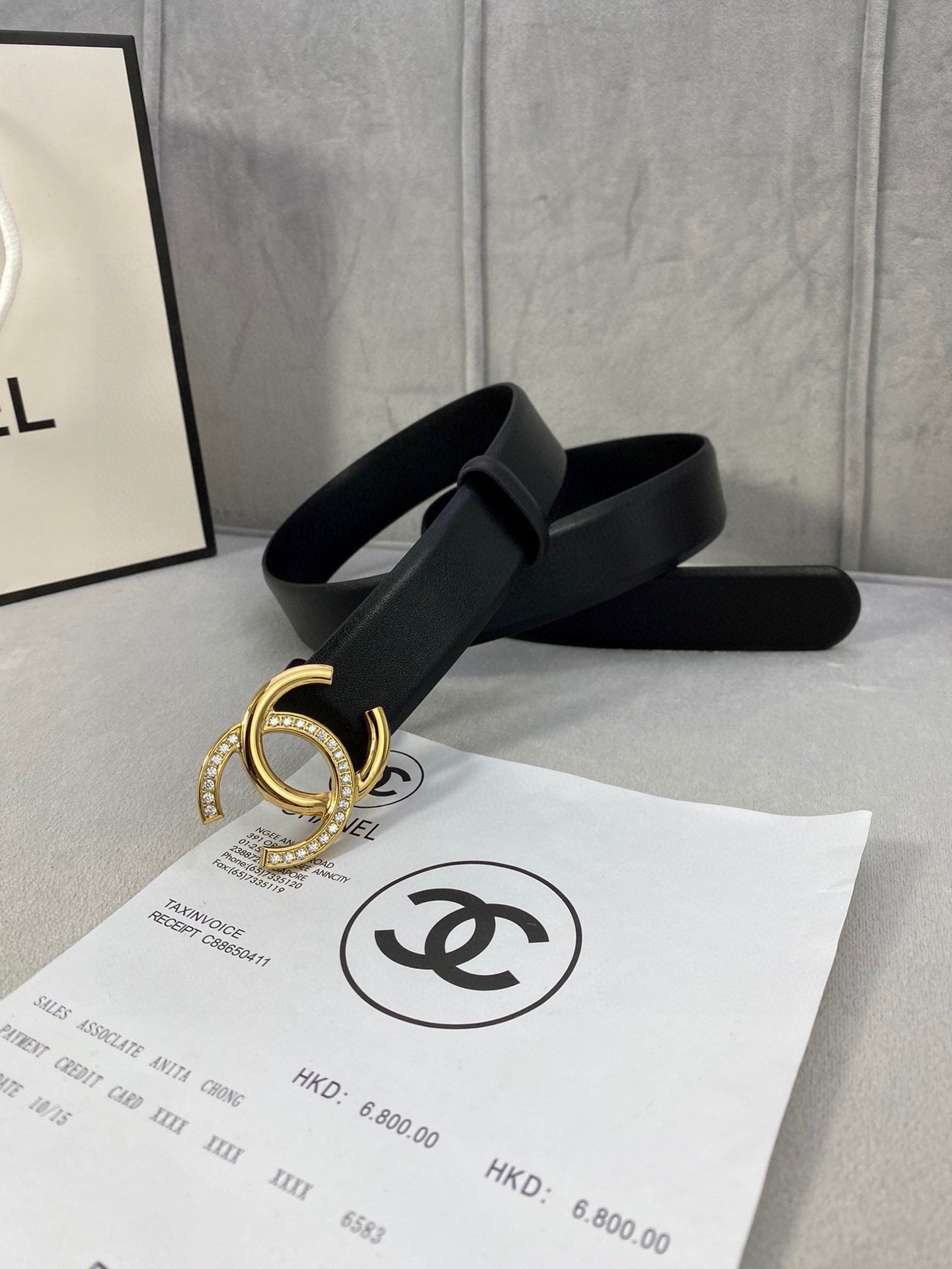Black leather belt with gold-tone CC buckle, flat strap view