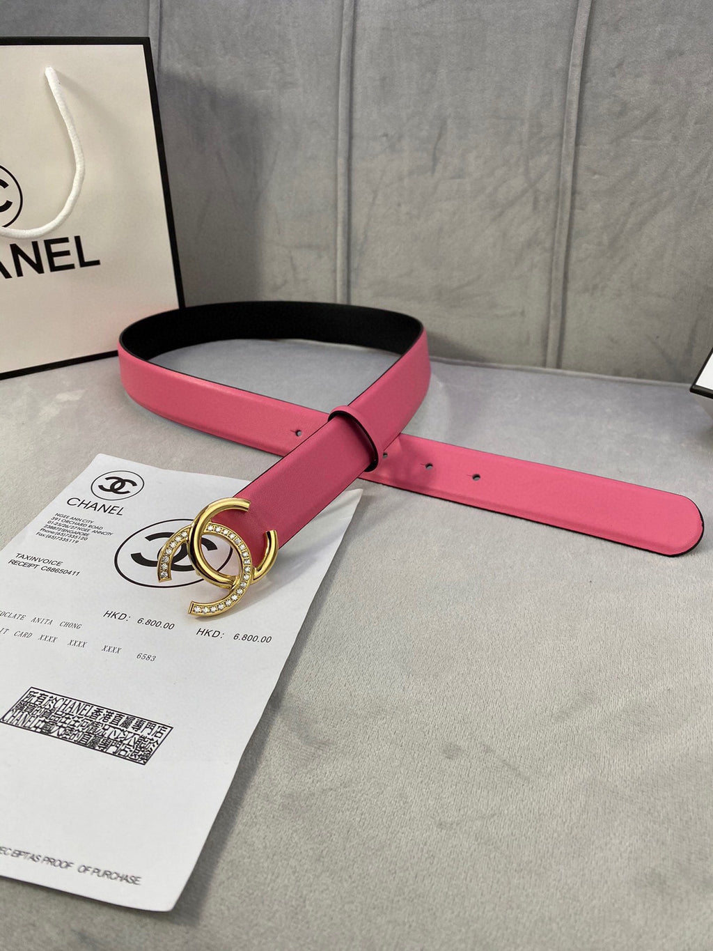 Chanel belt with pink strap and black underside, gold CC buckle and leather end