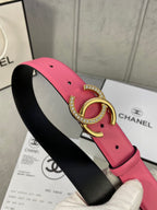Chanel belt close-up: pink strap with black underside and gold rhinestone CC buckle
