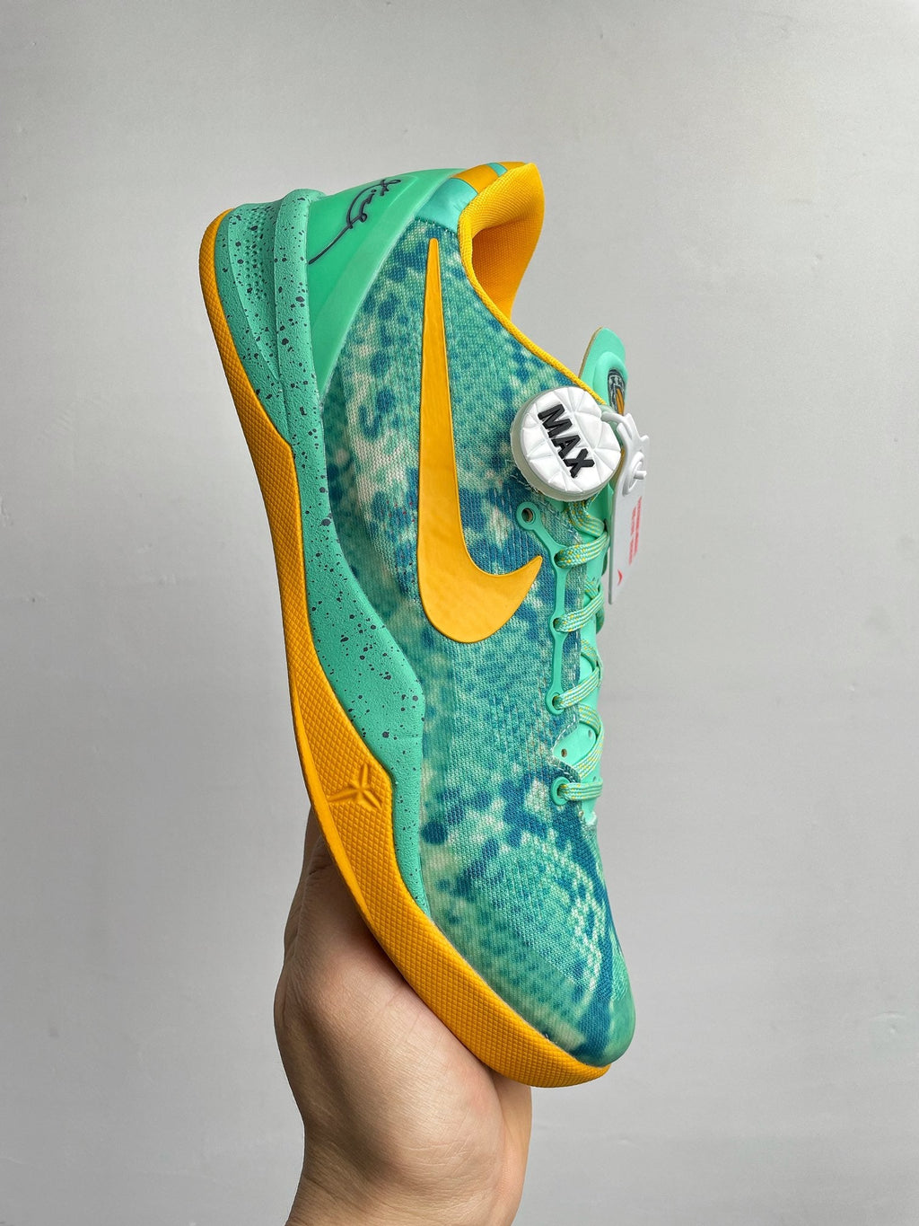 Teal basketball shoe with yellow heel panel, side swoosh, and lace-up front