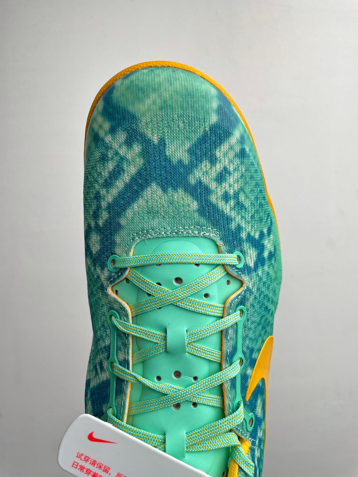 Teal basketball shoe toe box with neon laces and textured upper