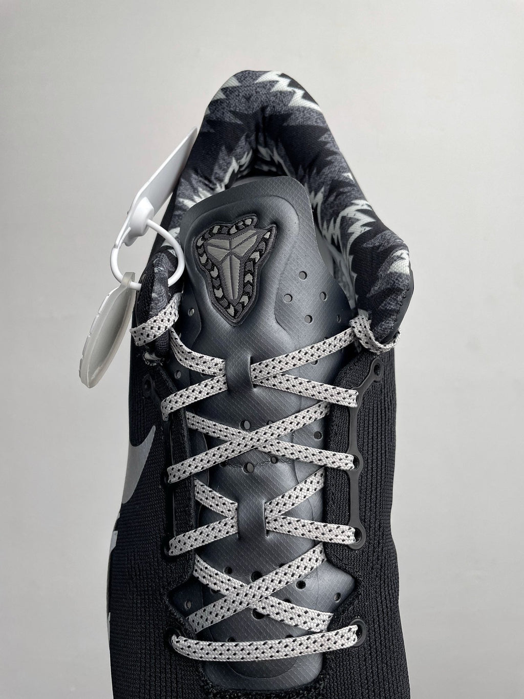 Black Nike basketball shoe with lace-up system, metallic-looking eyelets, and tongue tag