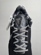Black Nike basketball shoe with lace-up system, metallic-looking eyelets, and tongue tag