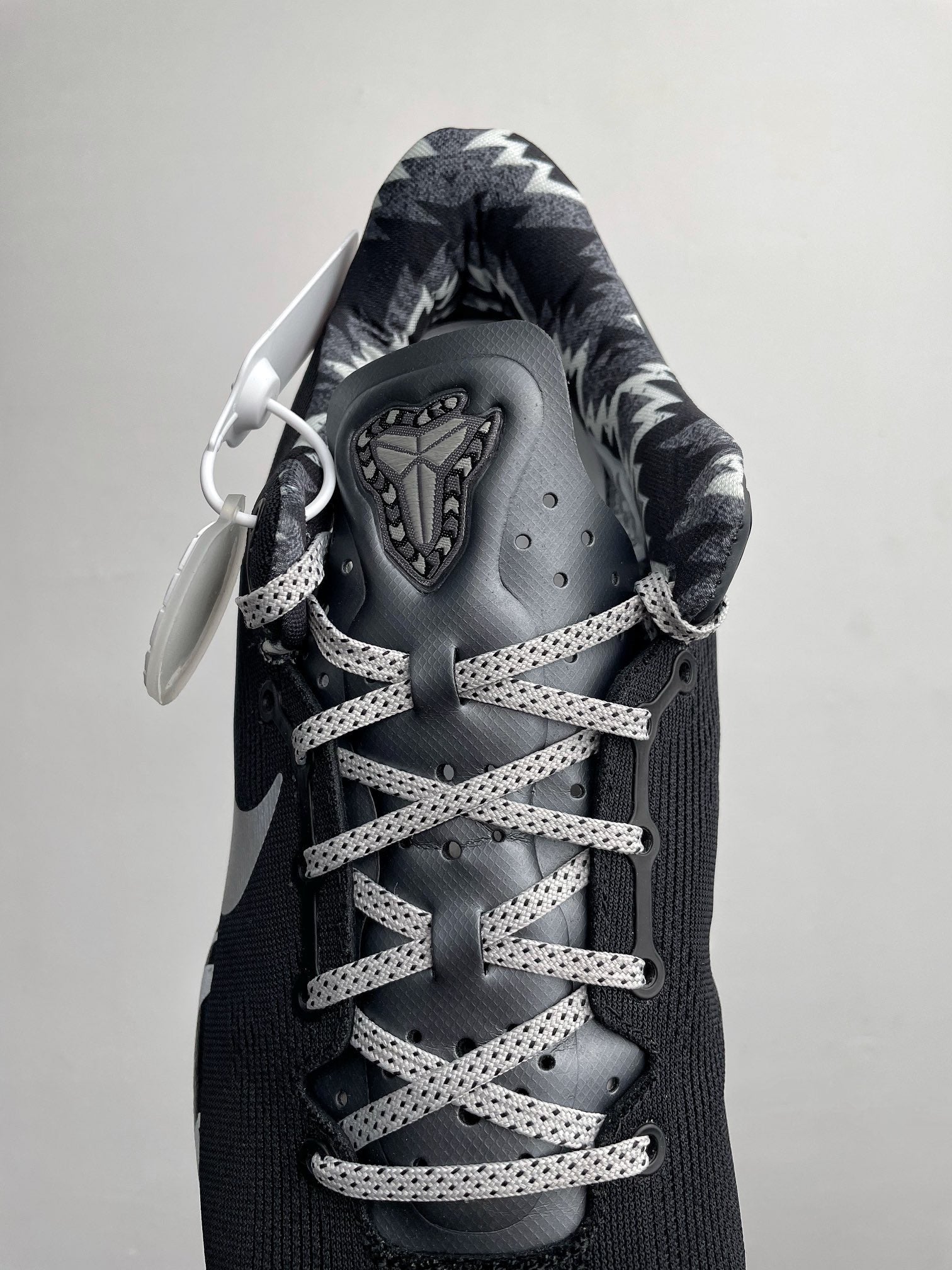 Black Nike basketball shoe with lace-up system, metallic-looking eyelets, and tongue tag