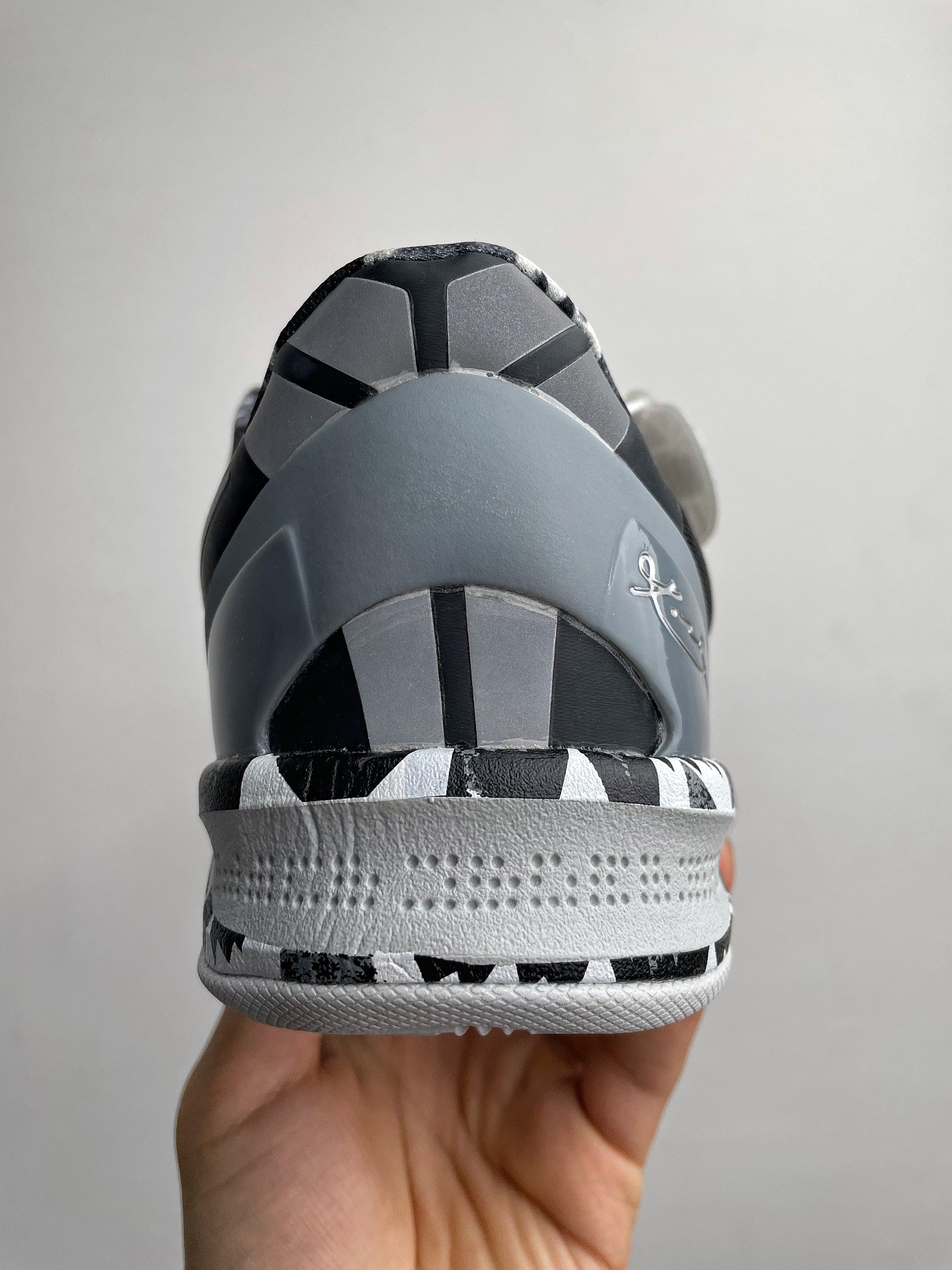 Heel view of black Nike basketball shoe with gray collar and textured midsole