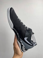 Three-quarter view of black and white Nike basketball shoe with Swoosh and laces