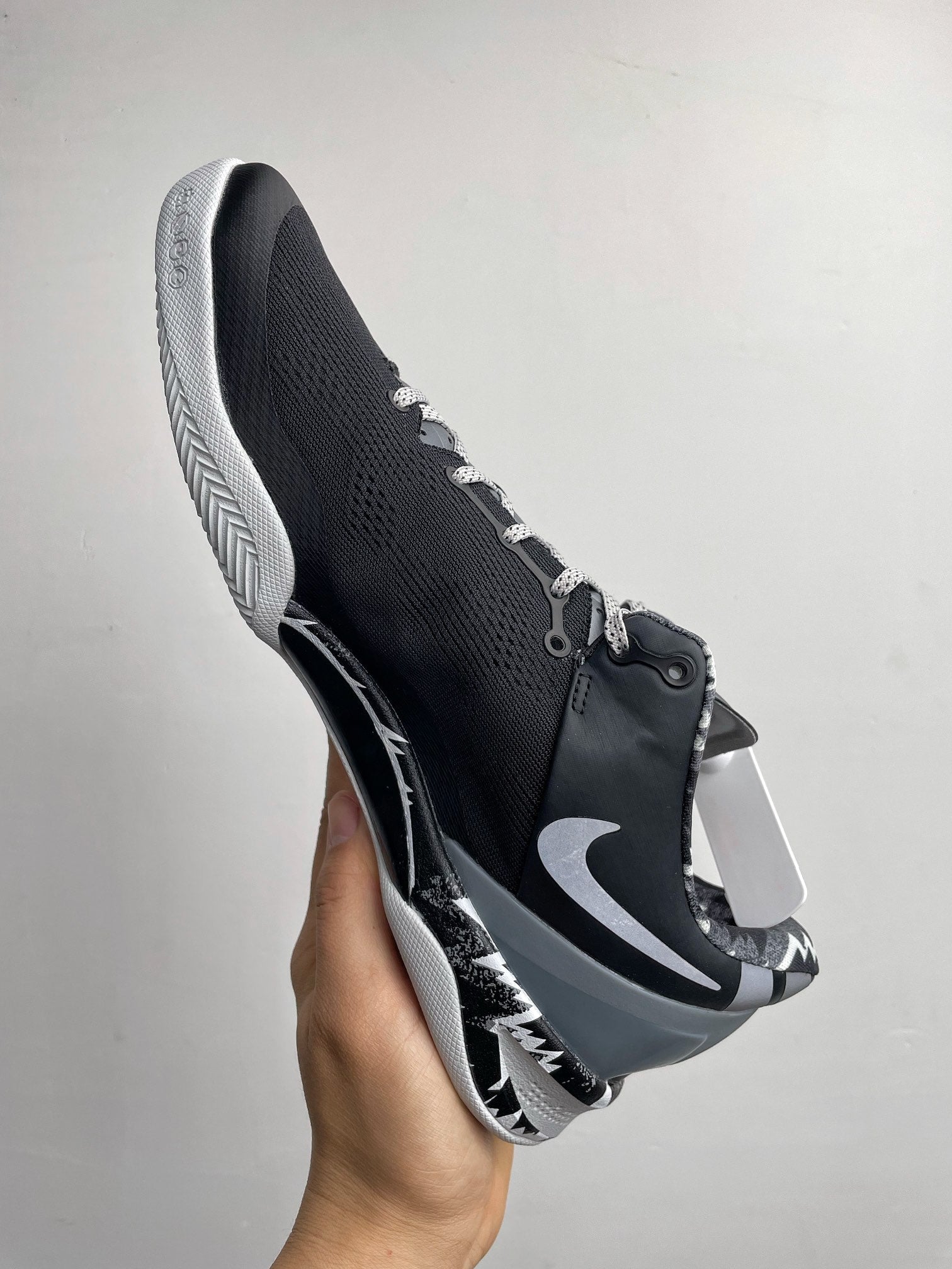 Three-quarter view of black and white Nike basketball shoe with Swoosh and laces