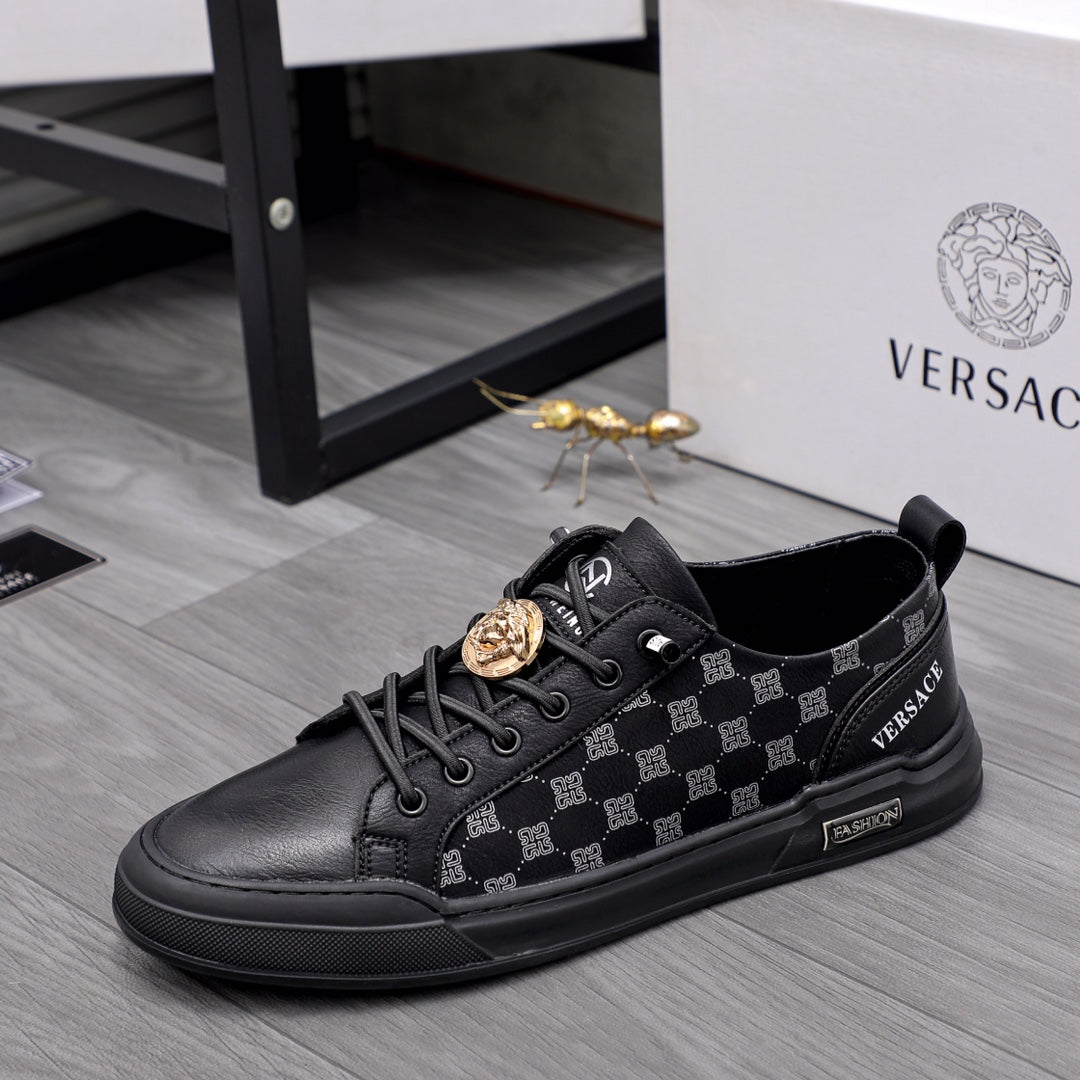 Black sneakers with monogram-style pattern, lace-up front, gold coin emblem on strap