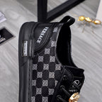 Black sneakers with patterned inner side, lace-up front, gold emblem ornament detail