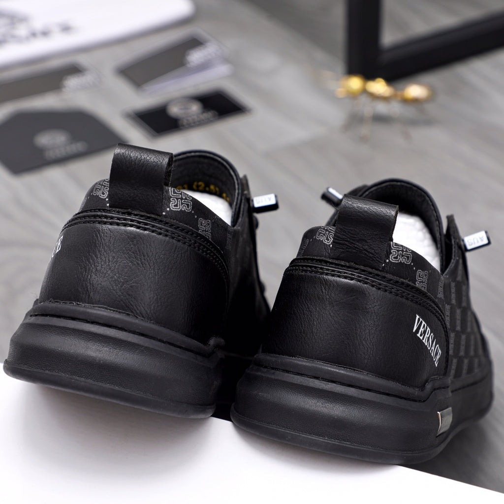 Back view black sneakers with logo heel tabs and treaded rubber sole