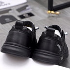 Back view black sneakers with logo heel tabs and treaded rubber sole