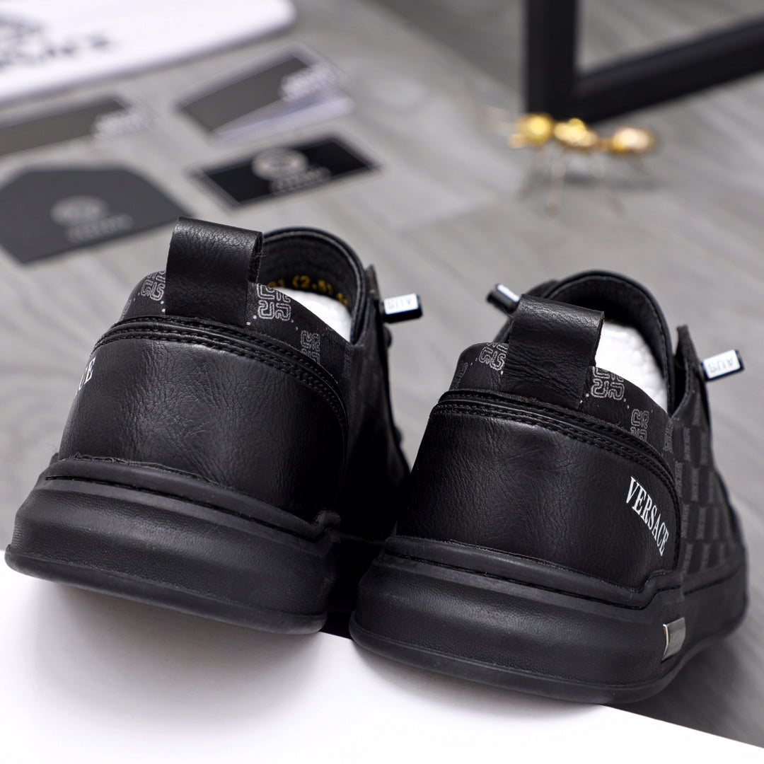 Back view black sneakers with logo heel tabs and treaded rubber sole