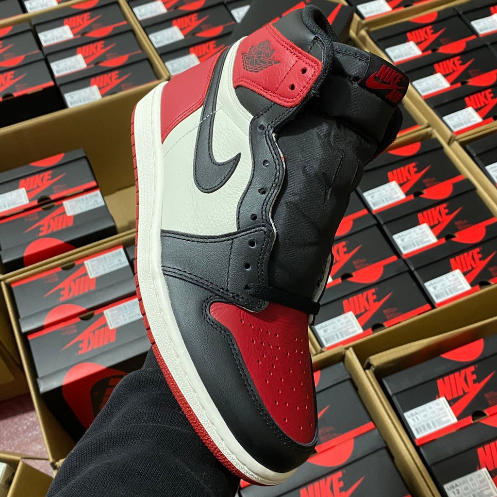 Black, white, and red high-top sneakers with Nike Swoosh and perforated toe panel.