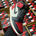 Black, white, and red high-top sneakers with Nike Swoosh and perforated toe panel.