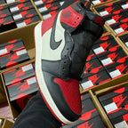 Black, white, and red high-top sneakers with Nike Swoosh and perforated toe panel.