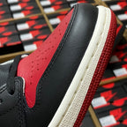 Black and red high-top sneaker with textured side panel and white midsole edge.