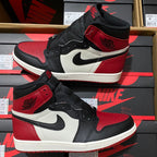 Black, white, and red high-top sneakers with Nike Swoosh, lace overlays, and wing logo.