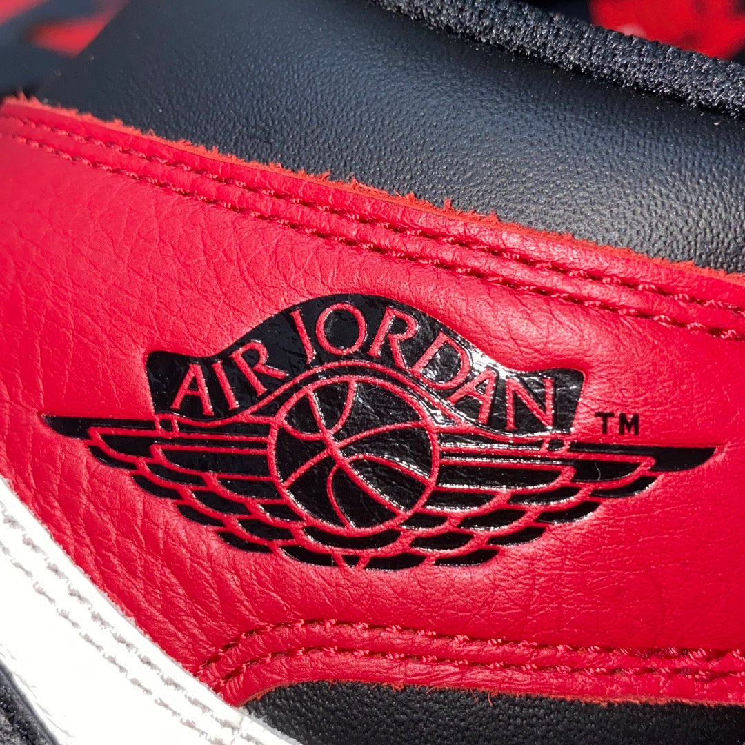 Red leather sneaker panel with Air Jordan wing logo and black lace guard trim.