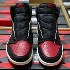 Black and red high-top sneakers with padded ankle, white midsole, and perforated toe.