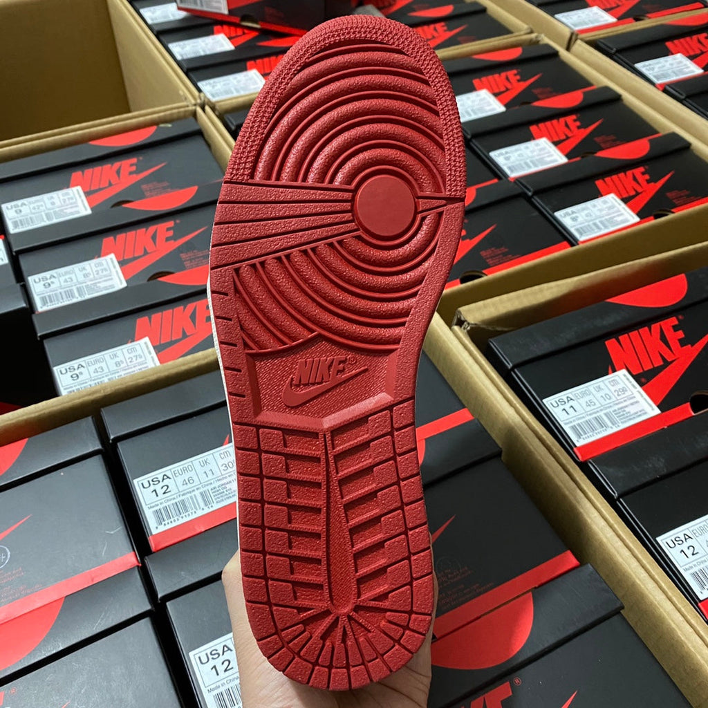 Red sneaker outsole with traction tread and circular pattern details.