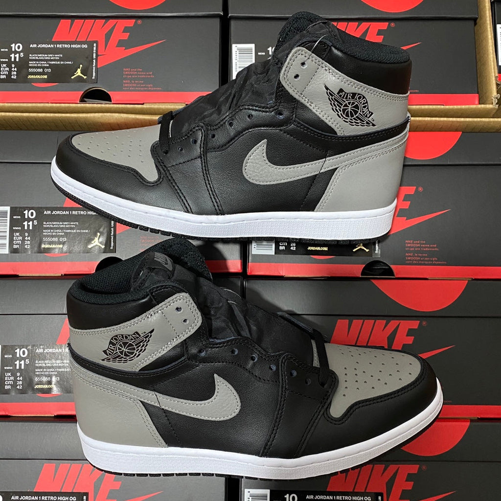 Pair of black and light gray high-top sneakers with white swoosh and padded ankle collar