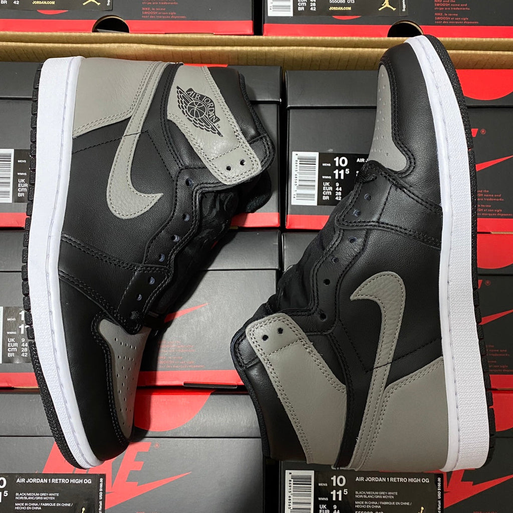 Black and light gray high-top sneakers with white midsole, swoosh logo, and lace-up uppers
