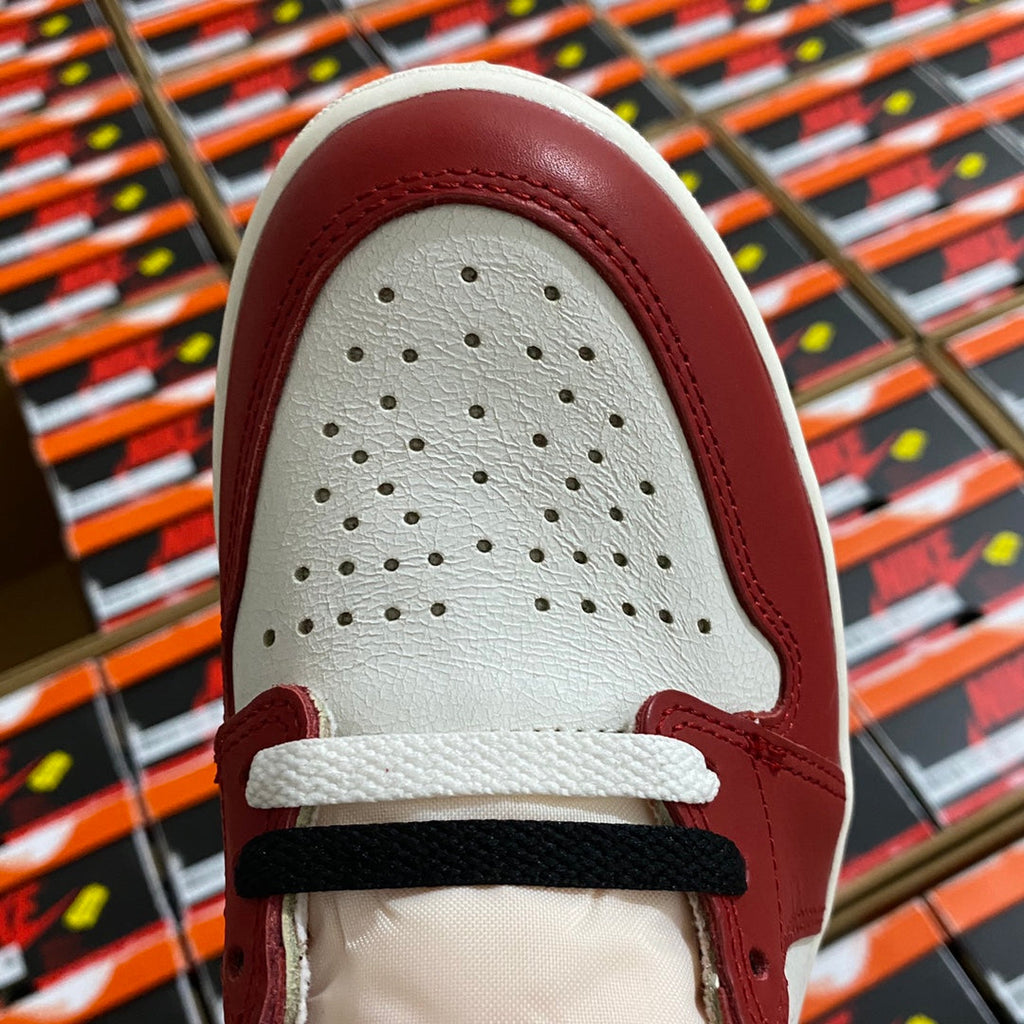 Leather sneaker toe box in burgundy and white with perforated ventilation holes.