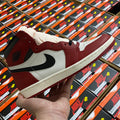High-top sneaker with white and burgundy panels, black swoosh, lace-up front.