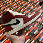 High-top sneaker with white and burgundy panels, black swoosh, lace-up front.