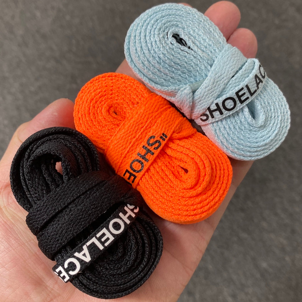 Rolled shoelaces set in black, orange, and light blue with printed text