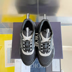 Two gray sneakers with black mesh and white accents, displayed on a purple box.